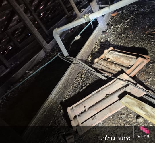 צינור ומבנה עץ בעליית גג עם חפצים ישנים